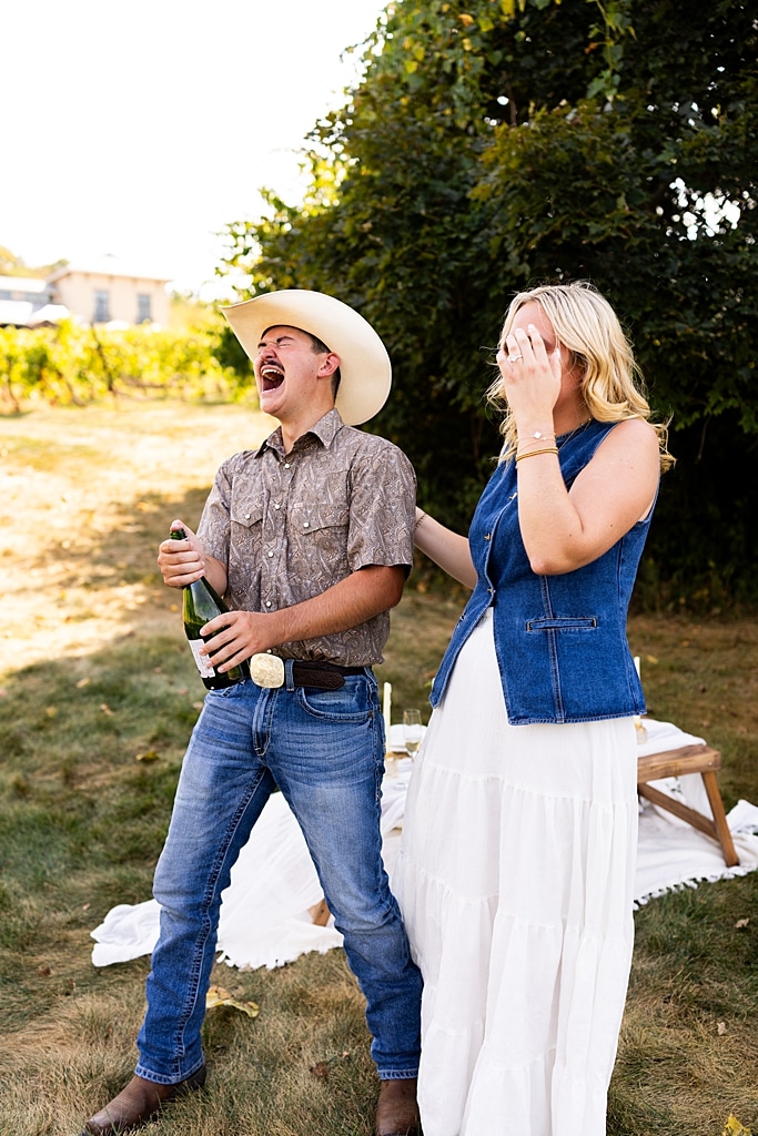 Tyler proposing to Rachel at Chandler Hill Vineyards in Defiance Missouri
Couple standing back to back moments before the surprise proposal
Rachel crying with joy as Tyler kneels during the proposal
Newly engaged couple hugging surrounded by vineyard scenery
Close up of engagement ring in front of rolling vineyard hills